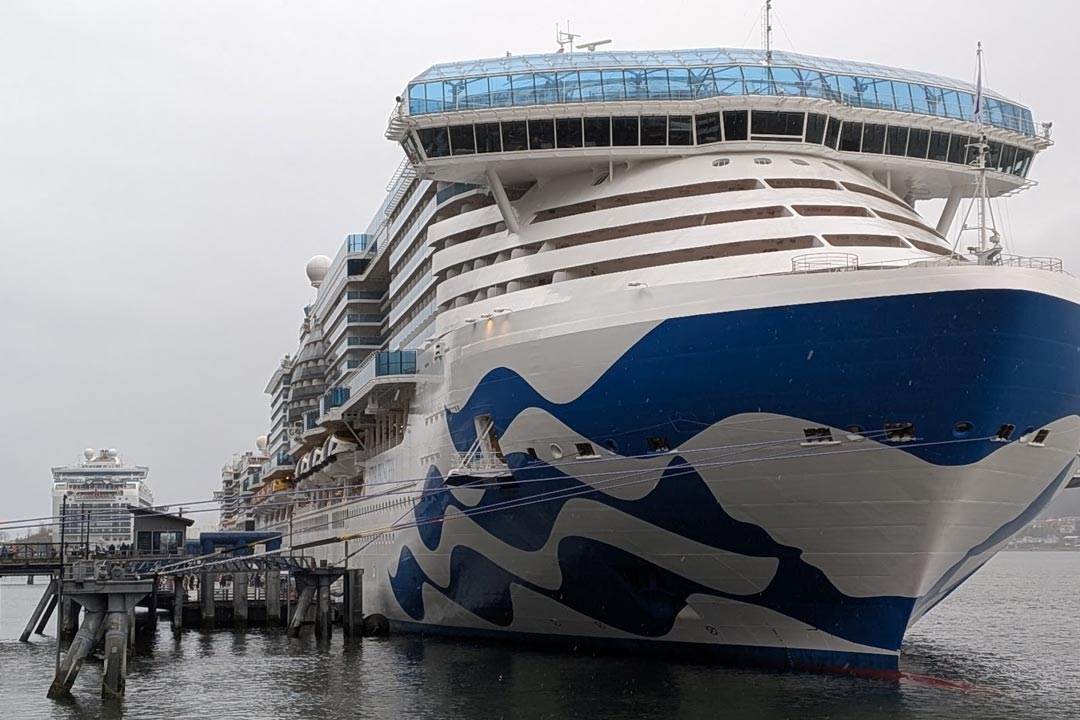 A large Princess Cruises ship docked at the Port of Juneau on an overcast day, showing rows of stateroom glass balconies perfect for mounting a GoPro timelapse rig.